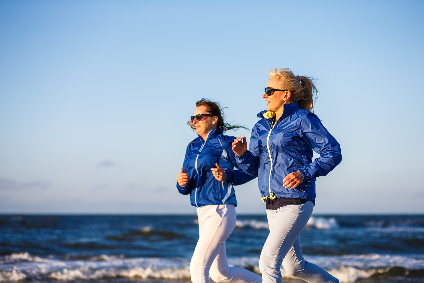 zwei Frauen joggen am Strand