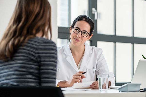 Frau sitzt einer Ärztin gegenüber